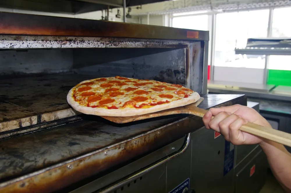 Pepperoni pizza coming out of the oven